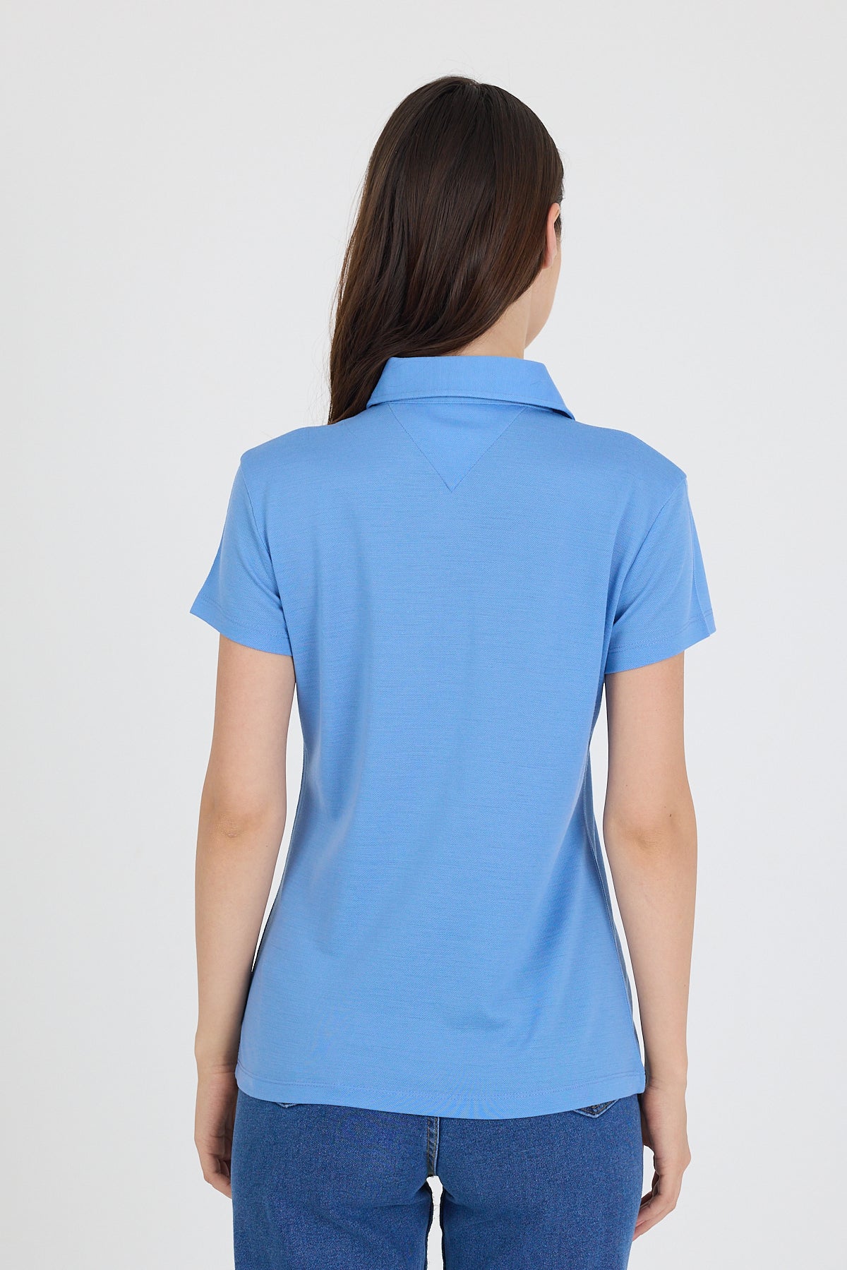Tył niebieskiej damskiej koszulki polo z wełny merino w stylu casual